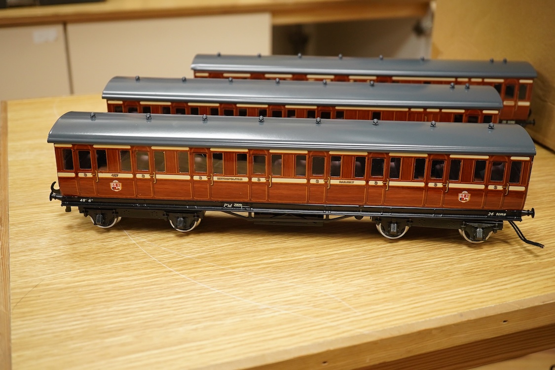 A boxed 0 gauge Darstaed tinplate Metropolitan Railway set of bogie coaches, a rake of five coaches in teak livery including; two Brake Thirds, two Full Thirds, and a Full First, fitted with internal lighting throughout